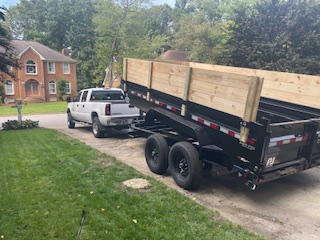 Dump trailer delivering mulch and gravel in a residential driveway